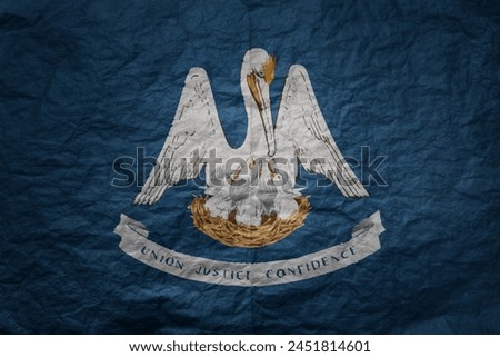 colorful big national flag of louisiana state on a grunge old paper texture background