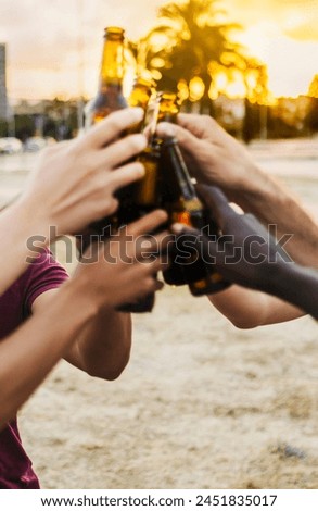 Vertical photo of unrecognizable group of people having cheering with bottle beers at summer party.