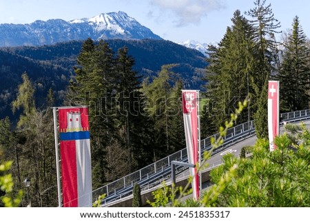 Scenic view from famous Bürgenstock Resort Lake Lucerne with flying flags and mountain panorama on a sunny spring day. Photo taken April 11th, 2024, Bürgenstock, Switzerland.