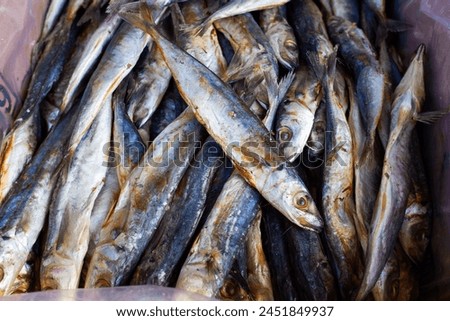 Pile of salted flying fish in a basket at the market, stock photo.
