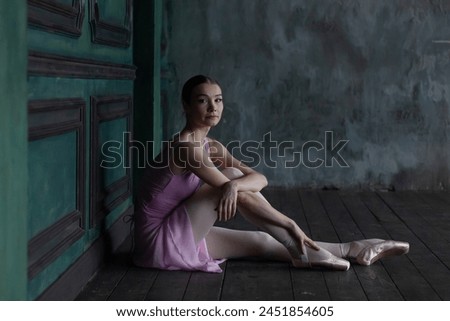 Portrait of a ballerina sitting on the floor.