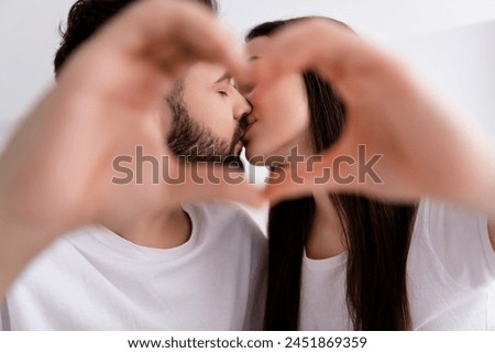 Photo of flirty charming husband wife nightwear cuddling kissing showing heart indoors house bedroom Royalty-Free Stock Photo #2451869359