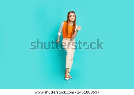 Photo of positive crazy glad girl wear orange stylish clothes friday night club isolated on aquamarine color background