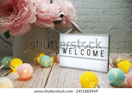 Welcome text on lightbox on wooden background