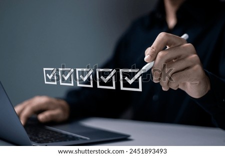 Checklist concept. Businessman using laptop to checking mark on checkboxes on virtual screen.