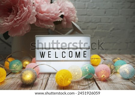 Welcome text on lightbox on wooden background