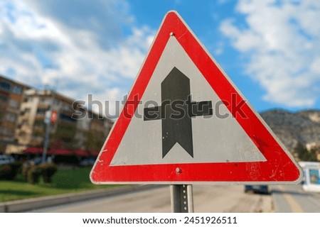 Secondary Road Ahead Sign with clear blue sky and urban landscape in the background. This image is ideal for use in content related to road safety, urban planning, and traffic management.