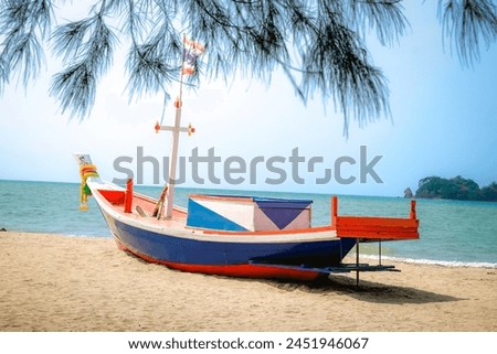 Fishing boats are parked on the sandy beach for tourists to take photos.