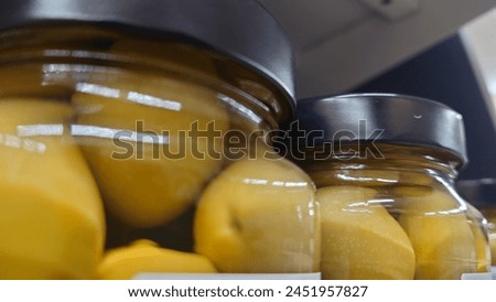 close up of pickled lemons in glass jars on the shelf at e edm pouring down, stock photo, natural light, high resolution photography, professional color grading, soft shadows, no contrast