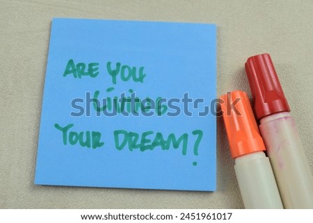 Concept of Are You Living Your Dream write on sticky notes isolated on Wooden Table.