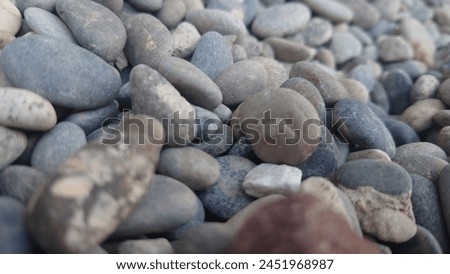 Closeup of pebbles, smooth and round rocks, muted colors, macro photography, high resolution stock photo. The image shows pebbles and smooth, round rocks in muted colors, photographed using macro
