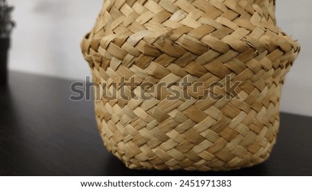 Close up of woven basket, detailed shot, product photography, high resolution, high quality, high details, high contrast, sharp focus, neutral background, white wall, black table, close up