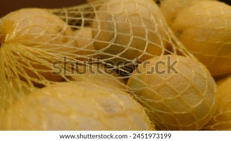 close up of yellow potatoe in net bag, closeup photography