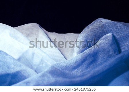White blue silk fabric on black background. Cobalt curtain tissue texture, folded dress textile. Marine ocean sea waves, indigo gradient chiffon clothing, azure 3d abstract water
