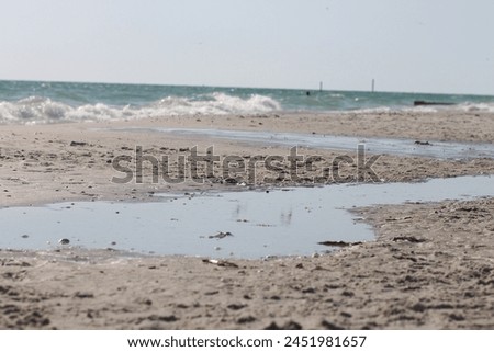 wet sand glistening under the sunlight at beach stock photo