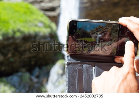 Female hiker photographing Waterfall Pericnik in the Triglav National Park of Slovenia