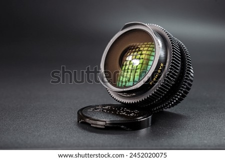 Fisheye camera lens with vivid reflections, set on lens cap, professional photography equipment, clear focus on the text and intricate lens design.