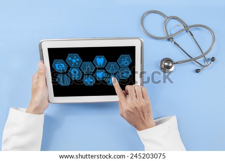 High angle view of doctor hands using medical icons on the digital tablet screen