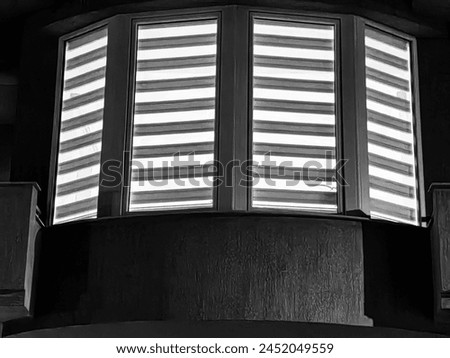 Nightfall Elegance. Window Frames and Blinds in Indoor Illumination. Dimly lit interior. Black and white, monochrome detail.
