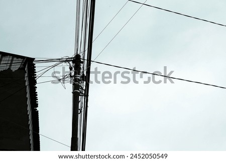 silhouette of electric cables piled up on electricity poles