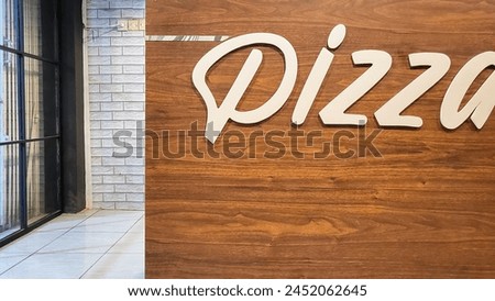A lettering or signage that was made for a pizza place on a wooden board