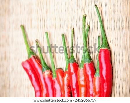 a photography of a group of red hot peppers on a wooden surface.
