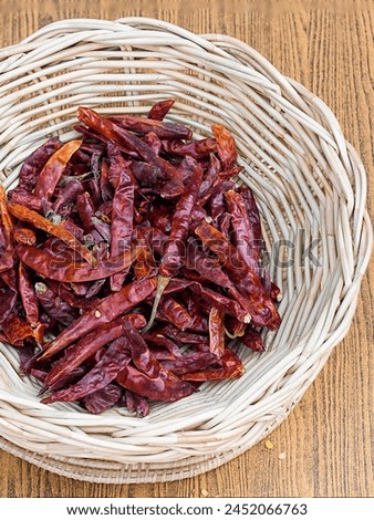 a photography of a basket of dried chilis on a table.