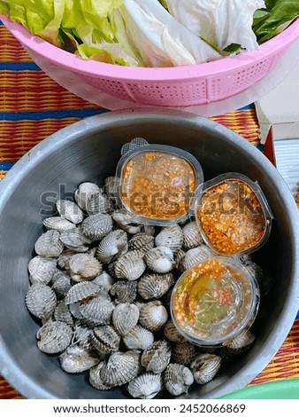 a photography of a bowl of clams and a bowl of lettuce. Royalty-Free Stock Photo #2452066869