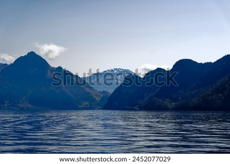 Scenic view of Lake Lucerne with Swiss Alps and snow covered mountains in the background on a sunny spring day. Photo taken April 11th, 2024, Kehrsiten, Canton Nidwalden, Switzerland.