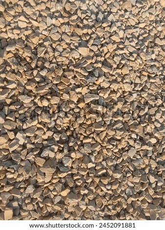 Mini little rock on the floor for a textured background. Brownish stones on the ground Royalty-Free Stock Photo #2452091881
