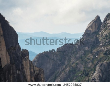 Deep canyon with sharp rocks. Awesome scenic view to great mountains in distance behind deep gorge. Wonderful mountain landscape with giant rockies and deep abyss. Perfect summer image for wall Royalty-Free Stock Photo #2452095837