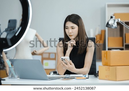 Businessman using smartphone and laptop computer in office. Happy woman, entrepreneur, small business owner working online.