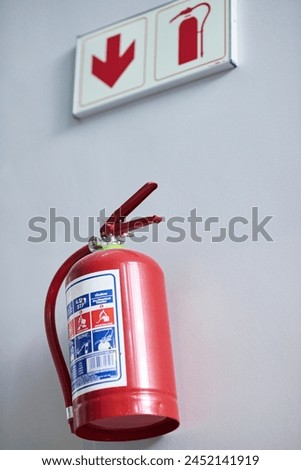 Fire extinguisher, wall and sign for firefighting, action and safety with emergency help and support. Portable dry and chemical powder to stop flame, air and oxygen for building equipment and arrow