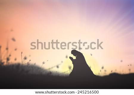 Silhouette Jesus Christ of Nazareth kneeling and praying at garden of Gethsemane background