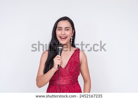 Portrait of a joyful Southeast Asian lady in a sparkling red gown, acting as an emcee or host at a gala night, isolated on a white background.