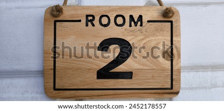 Room number sign number 3 is made of wood.