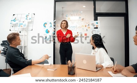 Young beautiful leader presents marketing strategy while expert investor and project manager listening and lecturing to analyze business performance at start up business meeting. Immaculate. Royalty-Free Stock Photo #2452184187
