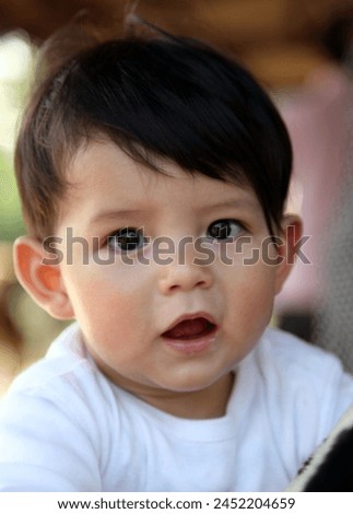 Hong Kong, Asia - 03 13 2011 : Exterior photo visual view portrait of a baby toddler 1 year old cute adorable handsome good looking with soft skin a eurasian features face in close up during say time