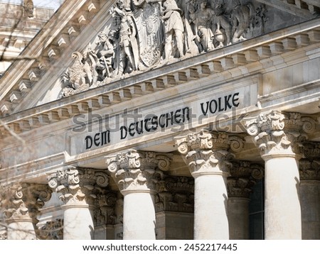 Dem deutschen Volke (To the German People) inscription close up of the Reichstag government building in the city of Berlin. Culture and history in Germany. Close up of the facade detail. Royalty-Free Stock Photo #2452217445