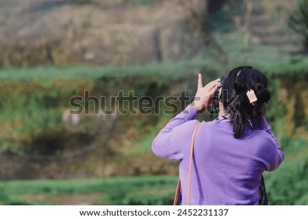 a woman takes a photo with a dslr camera