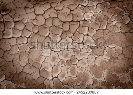 A close up of dry, cracked earth. Royalty-Free Stock Photo #2452239887