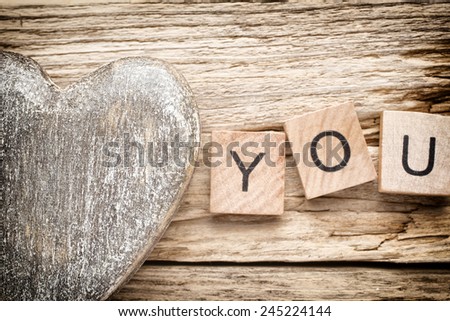 Wood heart on old wooden background - Stock Image. I love you, cast out of wood kubik.