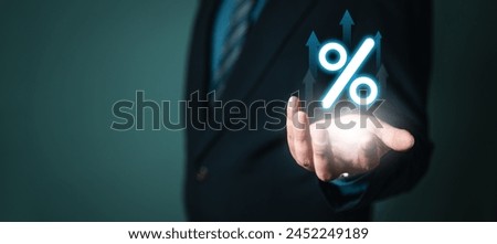 percent, commission, tax, income, vat, price, high, increase, rate, profit. A man is holding a hand up to a blue and white image of a percentage sign. The image is lit up and he is glowing.