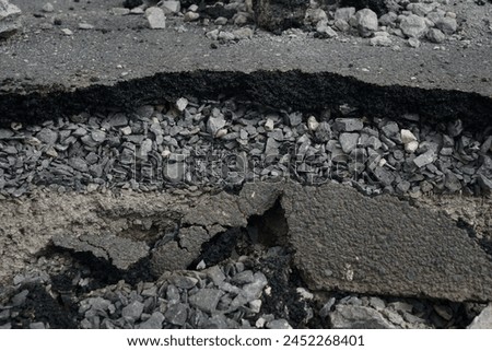 Asphalt road cross section in repair and reconstruction work. To show layer of surface and underground material. asphalt concrete, bitumen, soil, sand, rock, stone, crust, ground and earth. earthquake Royalty-Free Stock Photo #2452268401