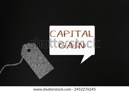 A tag with the word capital gain written on it. The tag is hanging from a string