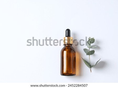 Eucalyptus essential oil in a glass bottle with green eucalyptus leaves on a wooden background. Aromatherapy concept. Spa. Natural organic ingredients for cosmetics and body care. Royalty-Free Stock Photo #2452284507
