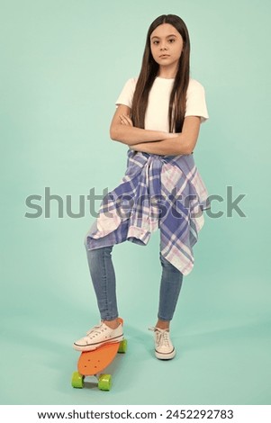 Fashion teenage lifestyle, beautiful teen girl with skateboard isolated on studio background.