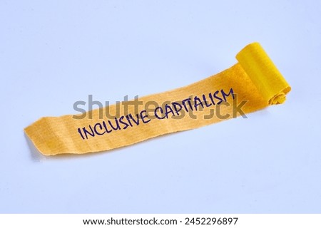 Business inclusive capitalism concept. Copy space. Words Inclusive capitalism on torn paper on a blue background