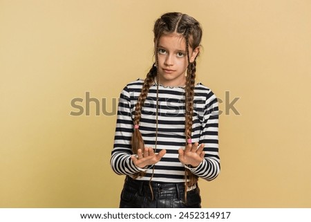 Hey you, be careful. Strict preteen child girl kid warning with admonishing hands gesture saying no be careful scolding and giving advice to avoid danger sign. Teenager children on beige background