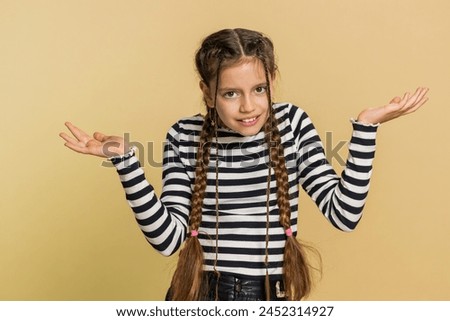 What. Why. Young school girl raising hands in indignant expression asking why what reason of failure, demonstrating disbelief irritation by troubles. Preteen child kid 10 years old on beige background Royalty-Free Stock Photo #2452314927